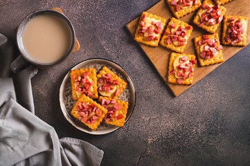 Spicy baked crackers with cheese and sausage on a plate on the table top view