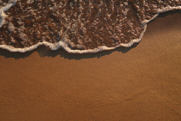 Photo of a sea wave on a sandy beach.  