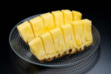 黒背景にガラスの器に盛ったカットパイナップル