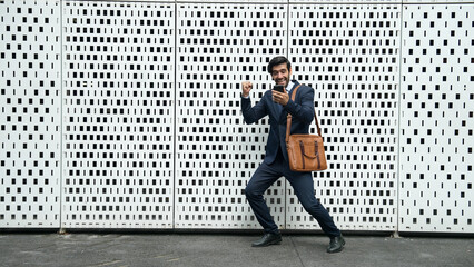 Happy skilled business man receive good news or getting a promotion while standing at white background. Smart executive manager happy and overjoy about successful project at city street. Exultant.