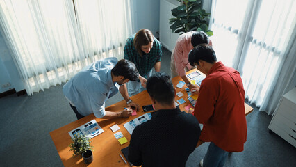 Top down view of team working together to compare and plan UX Ui design. Creative diverse business people in casual cloth discussing about marketing strategy or invest in startup project. Convocation.