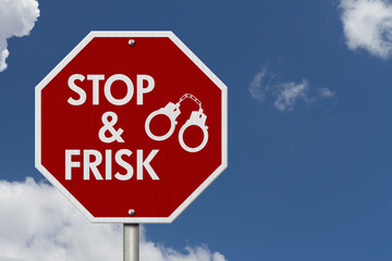  Stop and Frisk message with handcuffs on red street stop sign