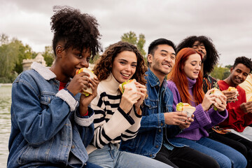 multiracial student friends have lunch together after school