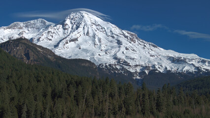 Fototapeta premium Majestic Snow-Covered Mount Rainier with Evergreen Forest in Foreground