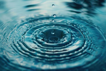 Close-up of a pristine water drop creating ripples in tranquil blue water