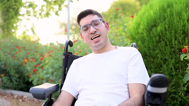 Video portrait of a happily smiling man with cerebral palsy in an outdoor park.Concept of people with cerebral palsy.