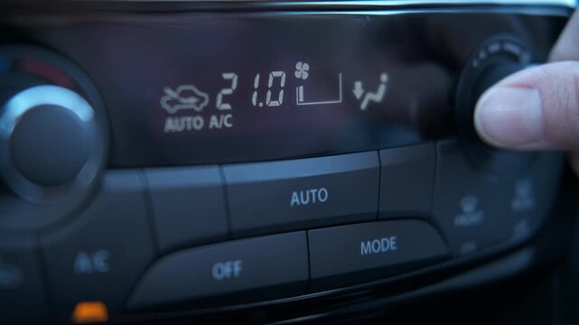 Use automotive air control in car. A view of female use the button of air control on the car panel inside. A concept of cooling the car cabin during hot weather.
