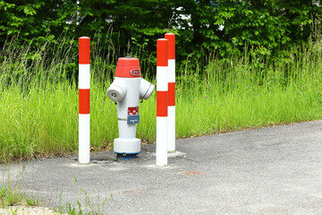 Red and white signal posts around a red fire hydrant.