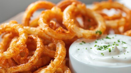 Naklejka premium Crispy fried onion rings served with creamy white dipping sauce