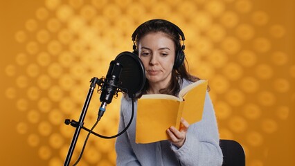 Woman does voiceover reading of book to produce audiobook using dramatic acting. Narrator uses...