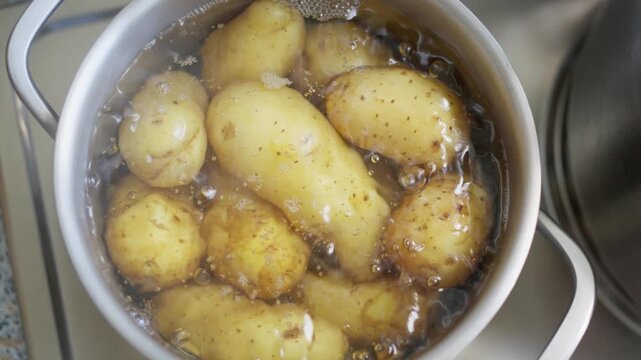 Fresh potatoes are currently boiling in water, perfectly prepared for cooking or further meal preparation. Slow motion