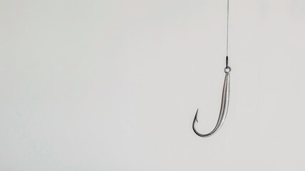 Single fishing hook suspended against plain white background