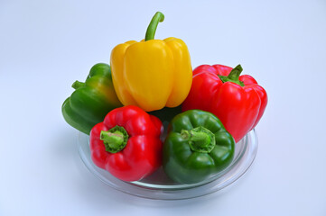 colorful sweet peppers on a plate close-up on a white background