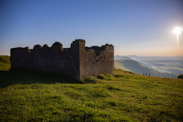 ruins of building in vast green landscape
