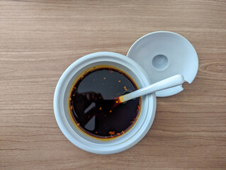 Spicy Hot Chili Crisp Oil in a white Bowl on top table, copy space.