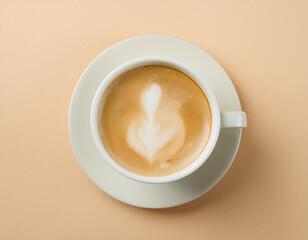 Top view of a white ceramic cup with a latte art on an pastel orange background.