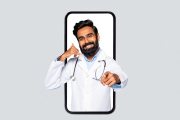 A smiling doctor in a white coat with a stethoscope is standing in a large smartphone. He is making a call me gesture with his left hand, and pointing at the viewer with his right.