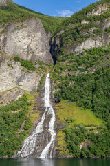 Cruising on Geiranger Fjord Norway Next to The Suitor Waterfall Rushing Down the Steep Mountain and Reflected in the Water