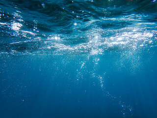 The sun shines through water, casting mottled light and shadow, intertwined with countless bubbles...