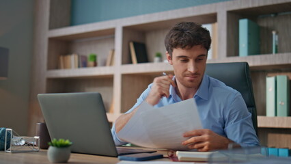 It manager doing research at workplace closeup. Thoughtful man making notes