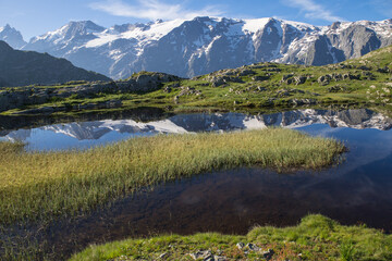 reflet des glaciers de la Meije sur un lac du plateau d'Emparis au refuge des Mouterres dans les Alpes en été	