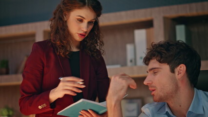 Two businesspeople solving business issues working together late evening closeup