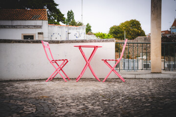 Pink chairs and table near a white wall