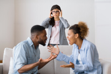 Marriage crisis. Shocked counselor witnessing black spouses fighting during couples psychotherapy. Empty space, selective focus