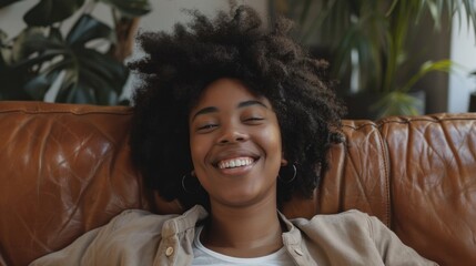 A woman sits comfortably on a couch with her eyes closed, appearing to be in a state of deep relaxation