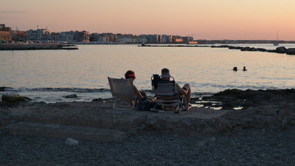 coppoia di persone al tramonto sul lungomare della città di Bari in Puglia