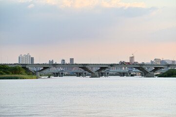At twilight from Dadaocheng Pier, gaze across the Tamsui River to Banqiao in New Taipei City, where a mix of high-rise buildings and under-construction sites add dynamic color to the skyline.