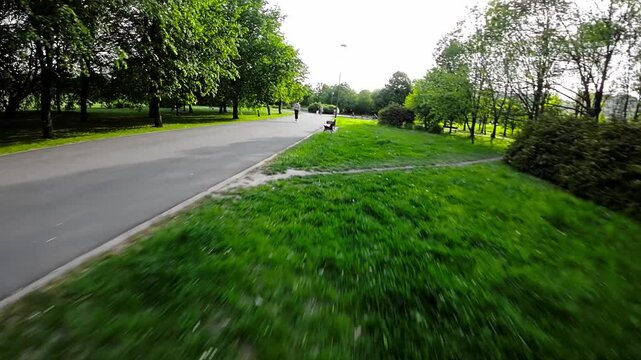 Join us on a serene journey through a picturesque park as we follow a rollerblader gliding along the smooth asphalt paths. Surrounded by lush greenery and the gentle sound of rustling leaves, the