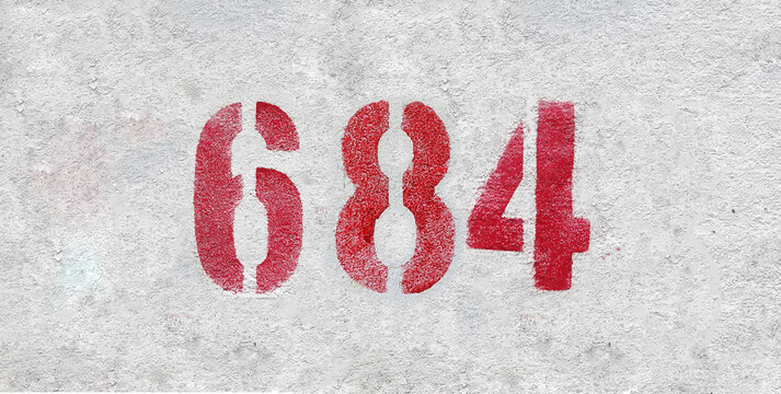 Red Number 684 on the white wall. Spray paint.