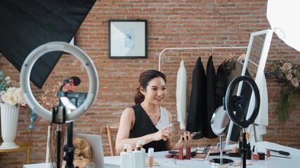 Woman influencer shoot live streaming vlog video review vivancy makeup social media or blog. Happy young girl with cosmetics studio lighting for marketing recording session broadcasting online.