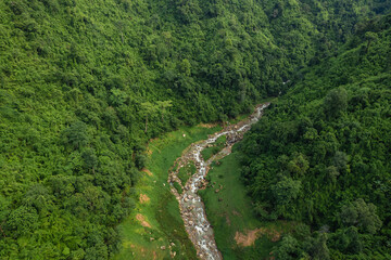 Beautiful aerial top view natural scenery of river in Southeast Asia tropical green forest with mountains in background.