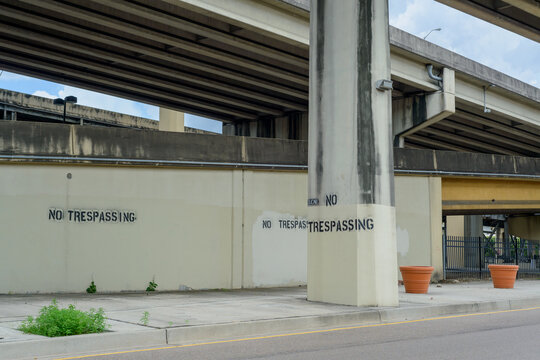Wall on Calliope Street, with the Avery C. Alexander Expressway Overhead, Displaying "No Trespassing" Signs after Removal of Homeless Squatters and Cleanup in New Orleans, LA, USA