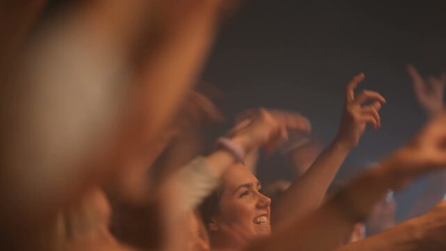 Party, dance and crowd with a group of happy people dancing or having fun at a concert or music event. Festival, audience and social with man and woman friends listening to music or dancing at a rave