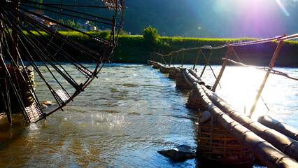 Wood water wheel Baler Machine in Agriculture Farm impeller lifted pumping water in river. Wooden Water Baler Machine green garden Farm blades by windy natural. Sustainable Resources Environment © aFotostock