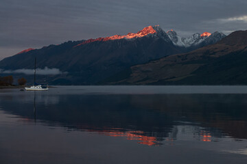 Sunrise at Lake Wakatipu, New Zealand. Sun shining on mountain peaks