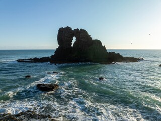 Rocky island in the ocean at Anawhata, Piha, Auckland, New Zealand.