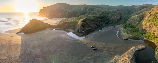 River estuary on sandy beach flowing to the ocean. Anawhata, Piha, Auckland, New Zealand.