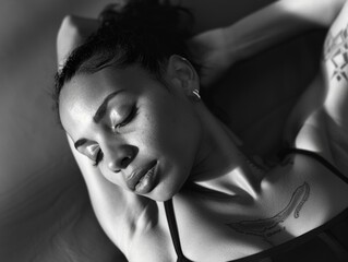 A woman lying down on a bed with her eyes closed, possibly resting or relaxing