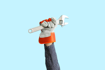 Female worker with wrench on blue background