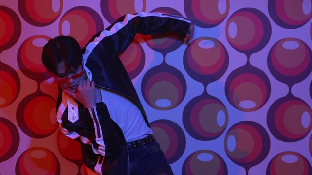Caucasian dancer in causal shirt perform break dancing while standing at party stage. Professional hipster looking at camera while moving hand and stretch arm to lively and freestyle song. Regalement.