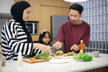Happy Asian mother father and daughter cooking together in home kitchen. Bonding concept.