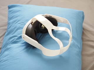 VR headset on pillow. Interacting with Augmented Reality lying on bed.