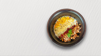 Breakfast bowl of yogurt oats and dry fruits placed on white table top view