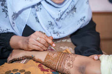 Obraz premium Mumbai, India 23rd July 2024: Close-up shots of an Indian bride getting henna also known as Mehendi or mehndi done. Henna pattern. Traditional Rasam or rivaz of done with henna mehandi