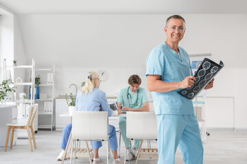Male doctor with MRI scan in clinic