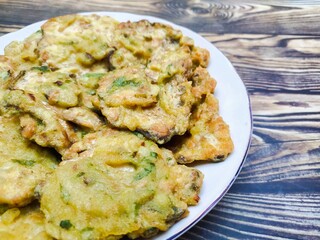 Traditional fried tempeh, or tempeh mendoan, or deep fried tempeh with spiced batter, is one of the most the most popular street foods from Indonesia. Fried tempeh on the wooden table.